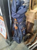 A set of golf clubs in canvas bag with folding trolley
