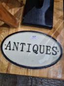 A reproduction cast iron sign for Antiques