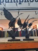 A modern metal sculpture of flying birds, approx 63cm wide