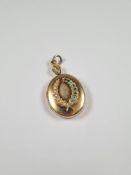 Unmarked yellow metal locket, possibly 18ct, large oval locket with 3cm x 2.5cm applied laurel wreat