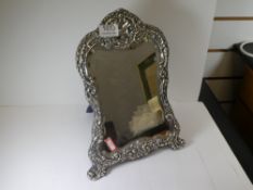 A very ornate decorative silver mirror having embossed details of flowers and scrolls. Pretty design