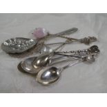 A small collection of silver and white metal spoons having various designs. One pierced and decorati