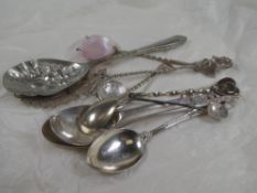 A small collection of silver and white metal spoons having various designs. One pierced and decorati