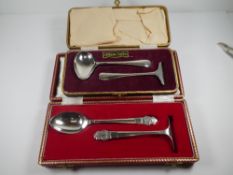 A cased silver pusher and spoon set having decorative embossed handles. Hallmarked Sheffield 1959, G