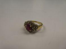 18ct yellow gold ruby and diamond cluster ring, with central oval cut ruby in 4 claw mount, surround