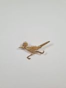 Vintage 14K gold brooch in the form of a roadrunner with red glass eye, approx 4.22g