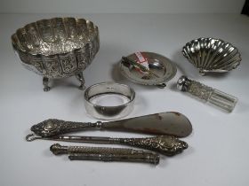 A very decorative white metal bowl having embossed details, scalloped rim and three figures holding