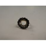 Unmarked yellow metal ring with large raised halo inset garnets, possibly originally mourning ring,