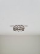 18ct white gold band ring with central row of rubover set round cut diamonds and decorative curving
