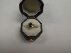18ct yellow gold sapphire and diamond cluster ring, central oval faceted sapphire surrounded small b