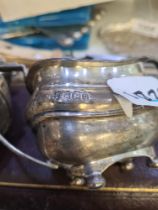 A silver two handled sugar bowl on four ball feet. Hallmarked Sheffield 1913 Sterwart Dawson and Co