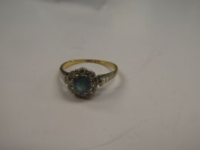 18ct and platinum cluster ring with central round cut aquamarine surrounded by small diamonds, size
