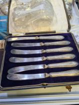 A cased set of silver handled knives hallmarked Sheffield possibly 1914 John Biggin. Also with some