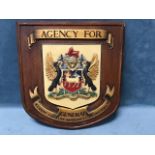 An insurance sign on an oak type shield shaped moulded board, with relief cast coat of arms framed