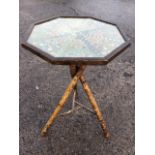 An octagonal glazed tray-top occasional table with patterned cigar labels under glass, supported