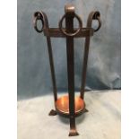 A circular tapering wrought iron stickstand on three supports with scrolled ring mounted
