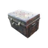 An old Victorian tin trunk with brass mounts, having studded hinged lid and carriage handles to