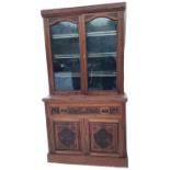 A Victorian carved mahogany secretaire bookcase, the top with arch glazed doors framed by fluted