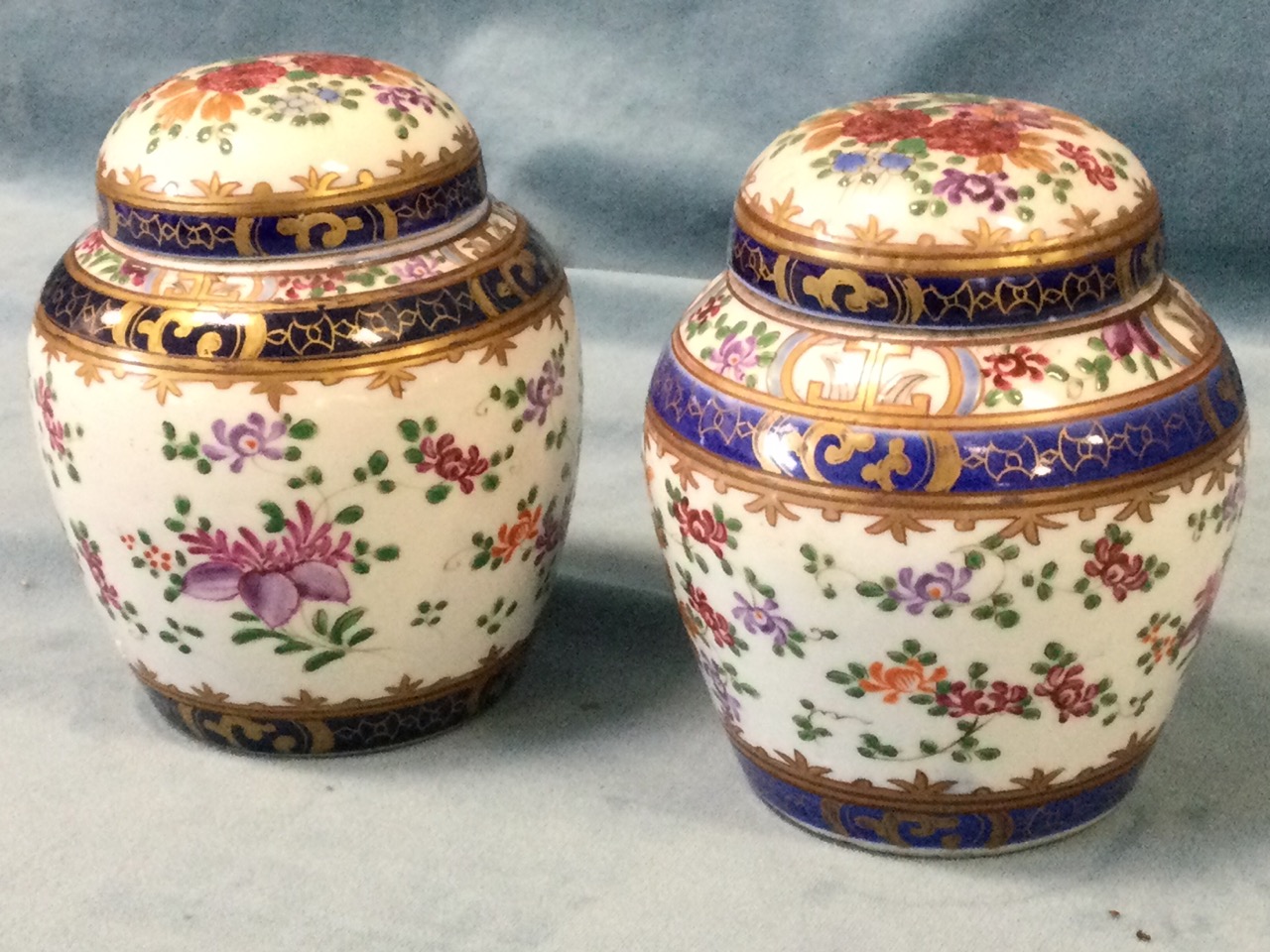 A pair of nineteenth century porcelain jars & covers decorated in the famile rose enamelled