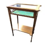 An Edwardian mahogany bijouterie table, the display case with projecting corners to hinged lid,
