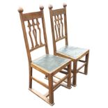 A pair of arts & crafts Liberty style oak side chairs with spade type finials to square tapering