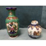 A tall Chinese vase decorated with floral bird panels on green bead enamelled ground, bordered by