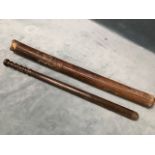 A long tapering hardwood truncheon with ribbed handle, in fitted leather sprung sleeve. (28in)