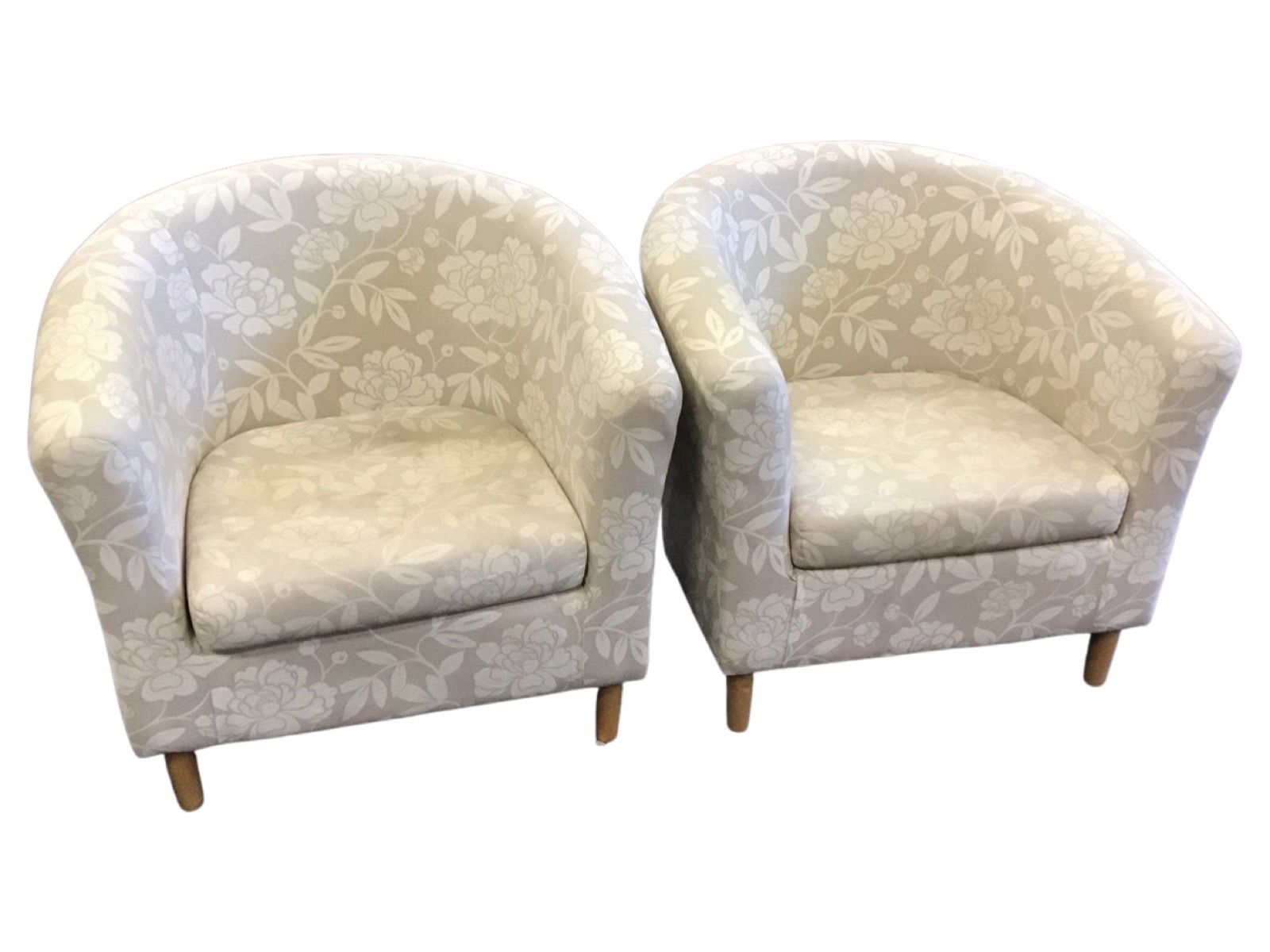 A pair of contemporary tub armchairs of horseshoe shape with loose cushions, raised on turned