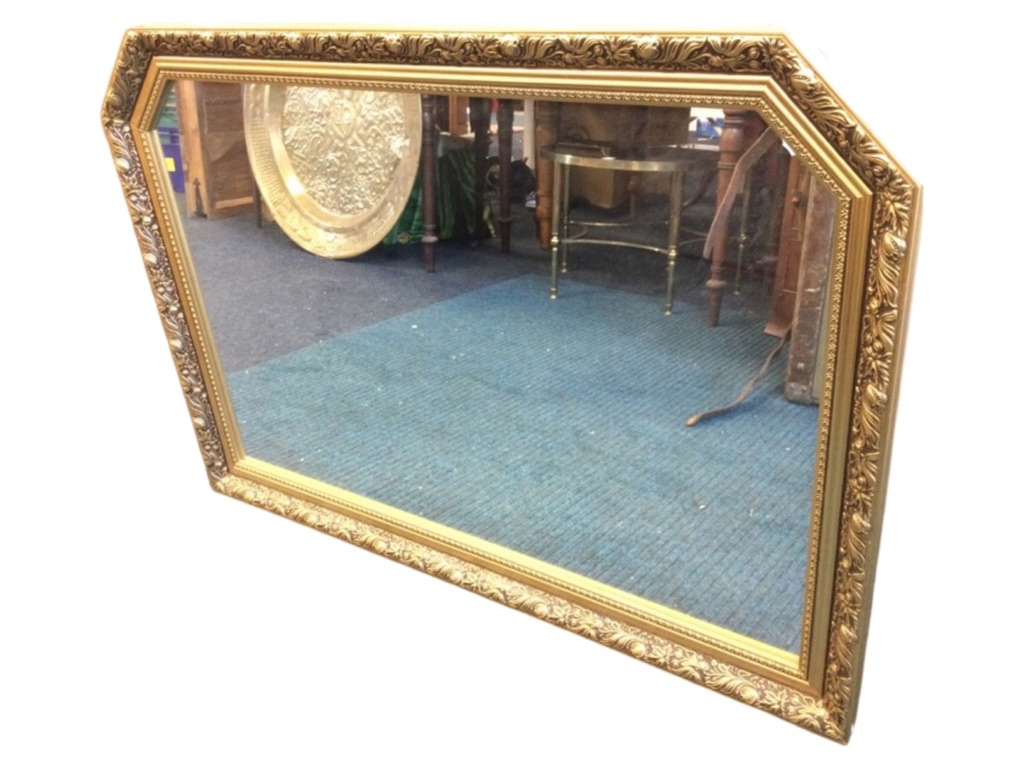 A rectangular gilt framed overmantle mirror, the plate in foliate moulded frame with canted corners.