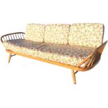 A 70s Ercol daybed sofa, with shaped ash board back and beech spindled ends, the rounded webbed seat