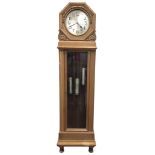 A deco oak longcase clock with circular silvered dial in octagonal cushion moulded case with