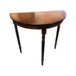 A D-shaped mahogany hall table with crossbanded top raised on turned tapering fluted legs. (29.75in