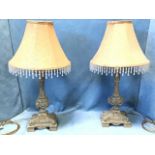 A pair of faux bronze tablelamps with beaded octagonal shades on columns above classical urns with