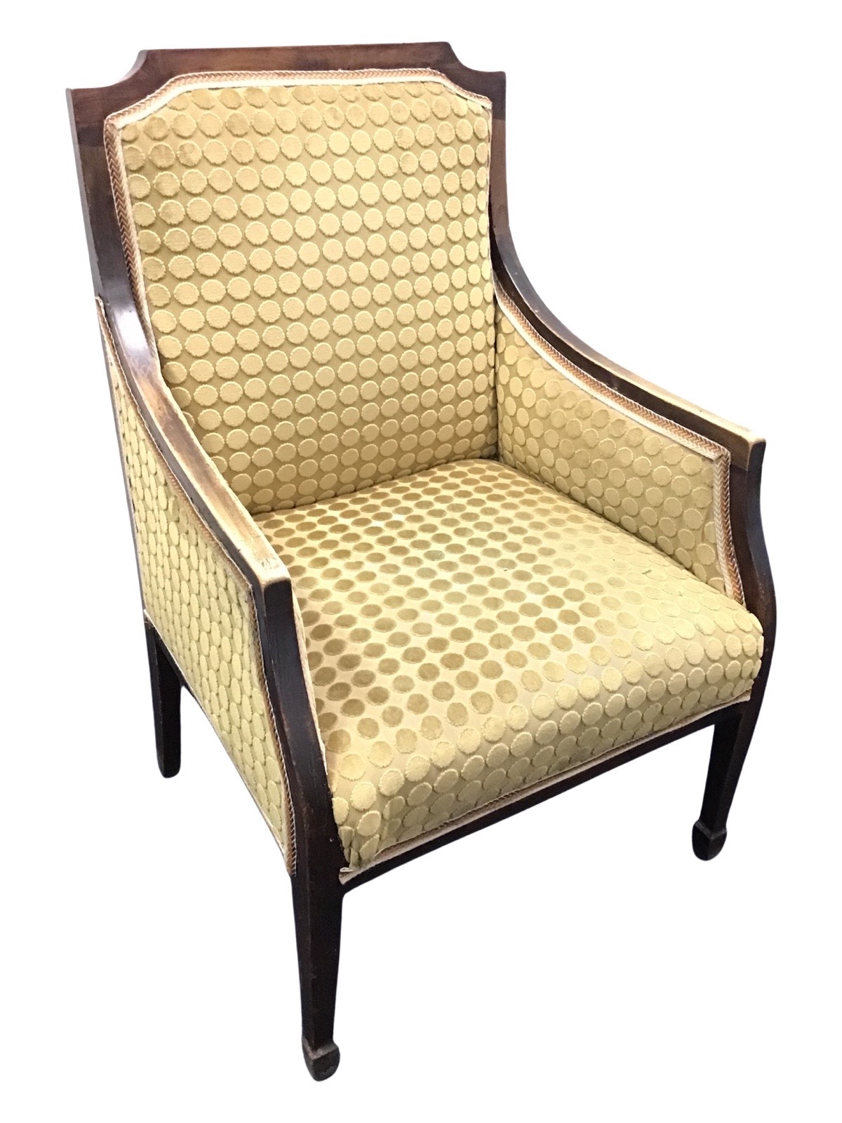 An Edwardian mahogany upholstered armchair, with downswept arms above a sprung seat, raised on