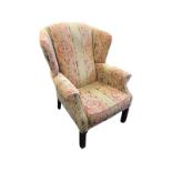 A Georgian style wing armchair with arched back and padded arms above a sprung seat with loose