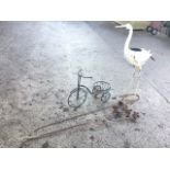 A painted metal garden heron type bird with plant pot to back; three rusty metal garden flowers on