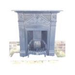 A cast iron fire surround with rectangular moulded mantelpiece above a decorative frieze with