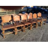 A set of ten leather upholstered oak dining chairs, the arched backs and stuffover webbed seats with