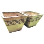 A pair of square tapering stoneware garden tubs decorated with floral scrolled glazed friezes on