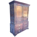 An eighteenth century country oak hall cupboard with moulded cornice above panelled doors