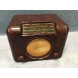 A Bush tortoiseshell bakelite cased valve radio with angled glass dial above a circular grill