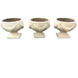 A set of three painted composition stone garden urns, the bulbous bowls cast with swagged decoration