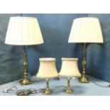A pair of large brass tablelamps, the columns on square plinths, mounted with pleated shades; and