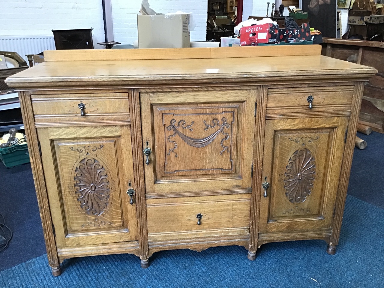 A late Victorian carved oak sideboard, the rectangular moulded top with upstand, above drawers and - Image 2 of 3