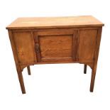 An Edwardian oak washstand with rectangular top above a central panelled door, raised on square