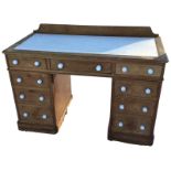 A Victorian pine kneehole desk, the rectangular moulded rounded top set with writing surface above