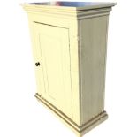 A Victorian painted cupboard, the rectangular top with moulded cornice above a panelled door, raised