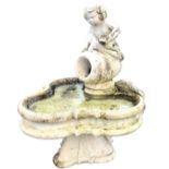 A composition stone garden fountain feature with cherub atop fallen pitcher above a shamrock