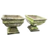 A pair of square composition stone garden urns, the shaped basins with overhanging rims moulded with