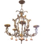 A gilt metal hanging light with pierced foliate scrolled frame beneath leaf moulded ceiling rose,